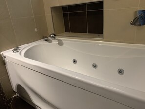 A white bathtub with a chrome faucet and a control knob. - Flatty Apartments - Stelvio (Milan)