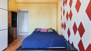 Um quarto com uma cama, um guarda-roupa e uma porta que dá para um banheiro.