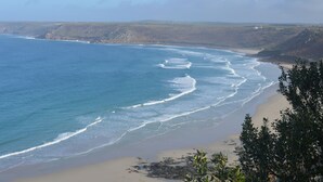 Eine Küstenlandschaft mit Strand, Klippen und blauem Himmel.