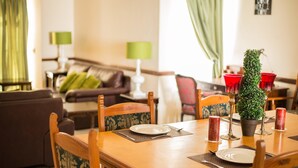 A dining area with a wooden table set for four, surrounded by chairs with patterned upholstery. - Eden Villas (Harare)