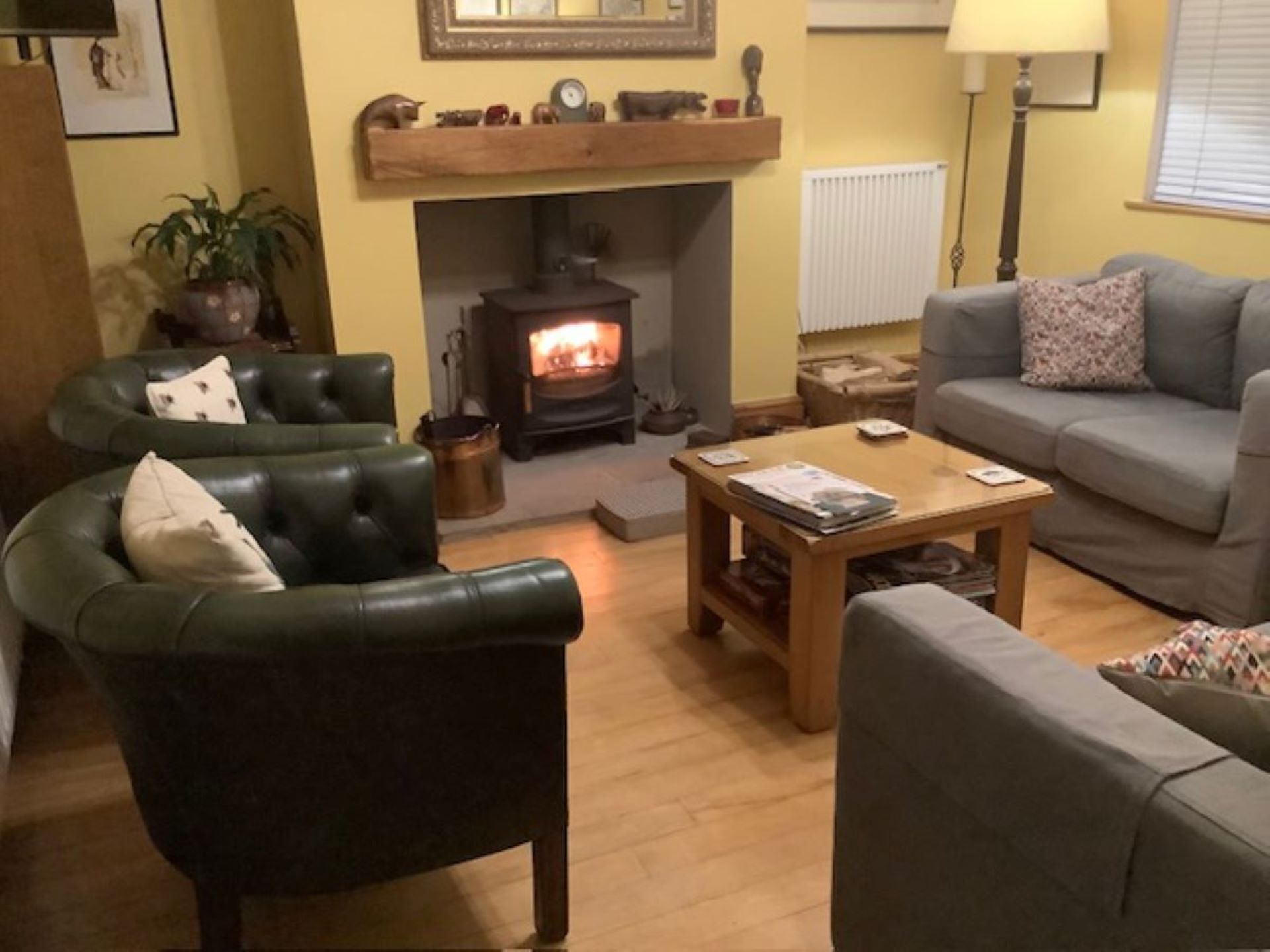 A cozy living room with a fireplace, leather armchairs, a sofa, and a coffee table.
