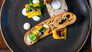 A plate with food items including bread, corn, and a small piece of meat. - The Congresbury Arms (Bristol)