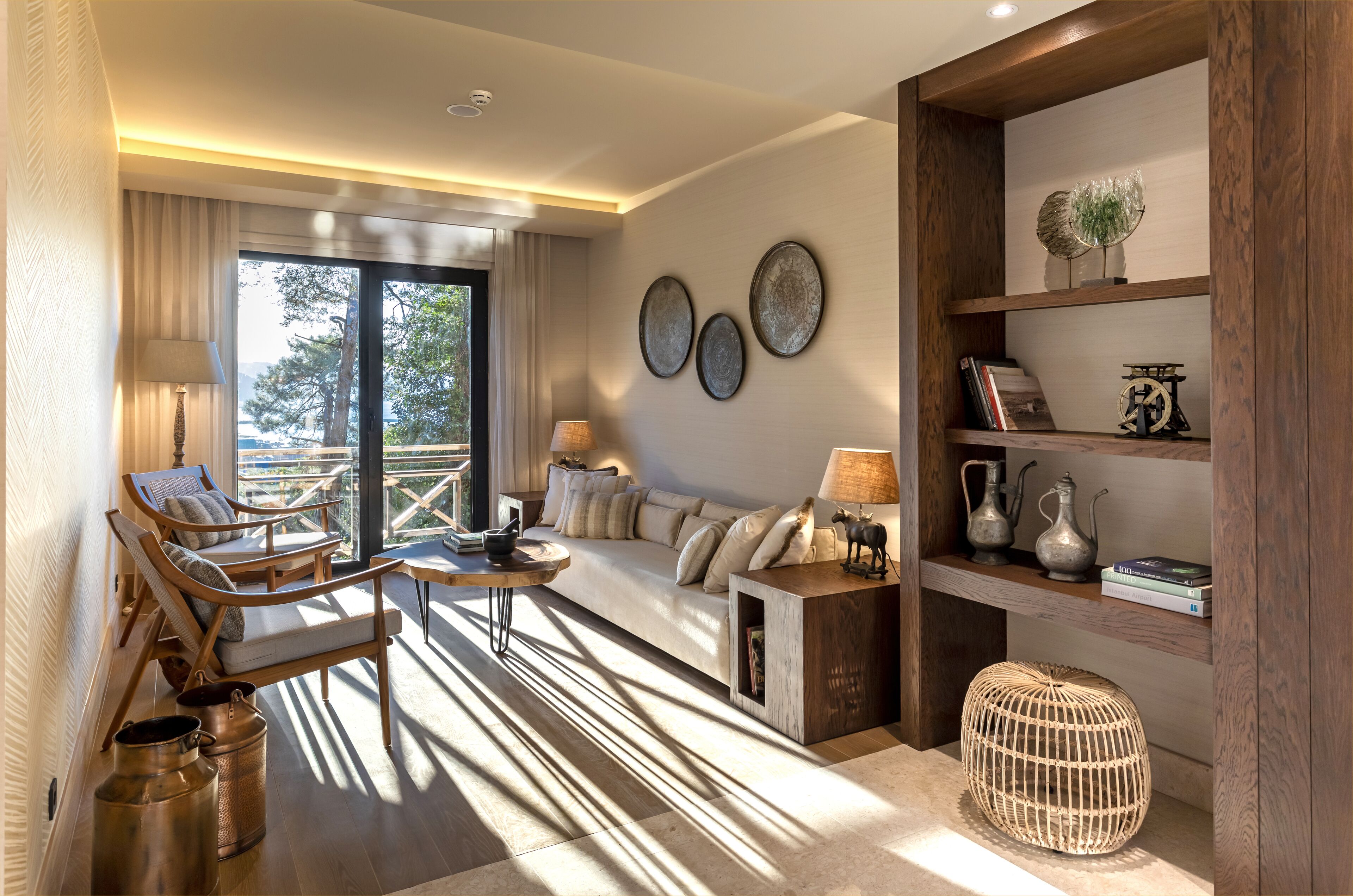 A modern living room with a sofa, chairs, a coffee table, and a bookshelf.