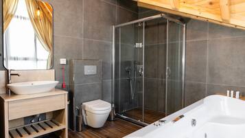 Un baño moderno con un espejo grande, un lavamanos blanco, un inodoro, una ducha con mampara de vidrio y una bañera independiente.