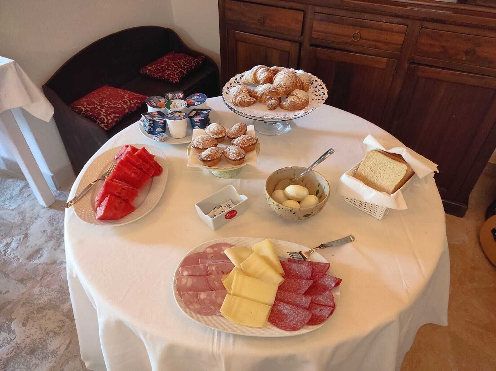 A table with various food items including pastries, bread, and cheese.
