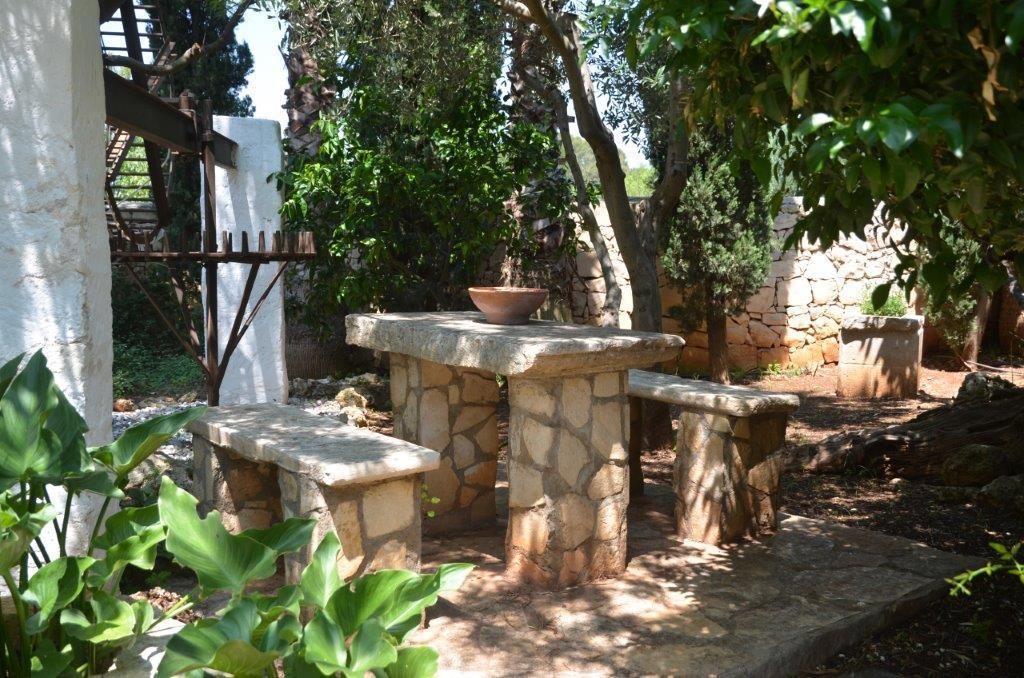 A stone table with benches in a garden setting.