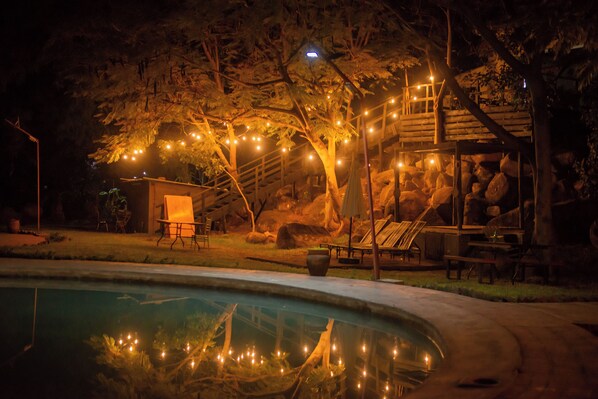 Una piscina al aire libre, sillones reclinables de piscina