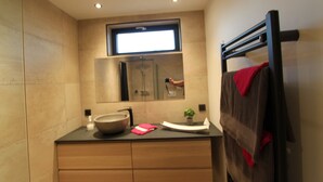 A modern bathroom with a large mirror, a towel rack, and a sink. - La chambre des Onglous (Marseillan)