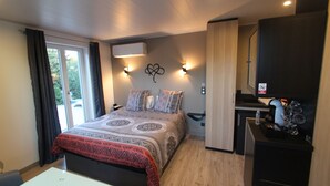 A bedroom with a bed, bedside tables, a desk, and a wardrobe. - La chambre des Onglous (Marseillan)