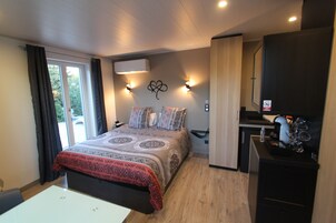Quarto com cama, mesas de cabeceira, escrivaninha e guarda-roupa.