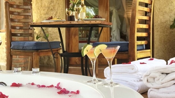 Una mesa servida con una copa de martini, un plato de comida y una botella de vino.