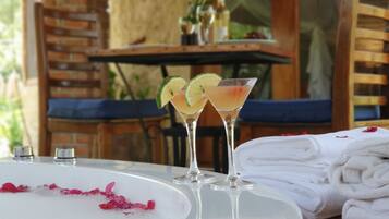 A table with a white surface, two martini glasses with lime slices, and a stack of white towels.