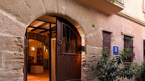 Un edificio de piedra con una puerta de madera y un letrero azul que indica un hotel.