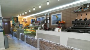 Una cocina moderna con un muro de acento de piedra, una vitrina con productos de panadería y una cafetera.