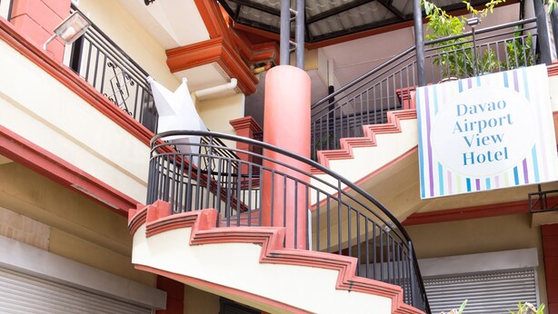 Un escalier en colimaçon avec une enseigne indiquant l’hôtel Davao Airport View.