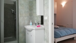 A bathroom with a shower, sink, and mirror. - Le mille e una notte (Comacchio)
