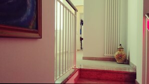 A staircase with a white railing, a radiator, and a vase on the landing. - Le mille e una notte (Comacchio)