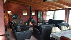 A cozy living room with leather sofas, a fireplace, and a television. - Masia Heredad La Boquilla (Enguera)