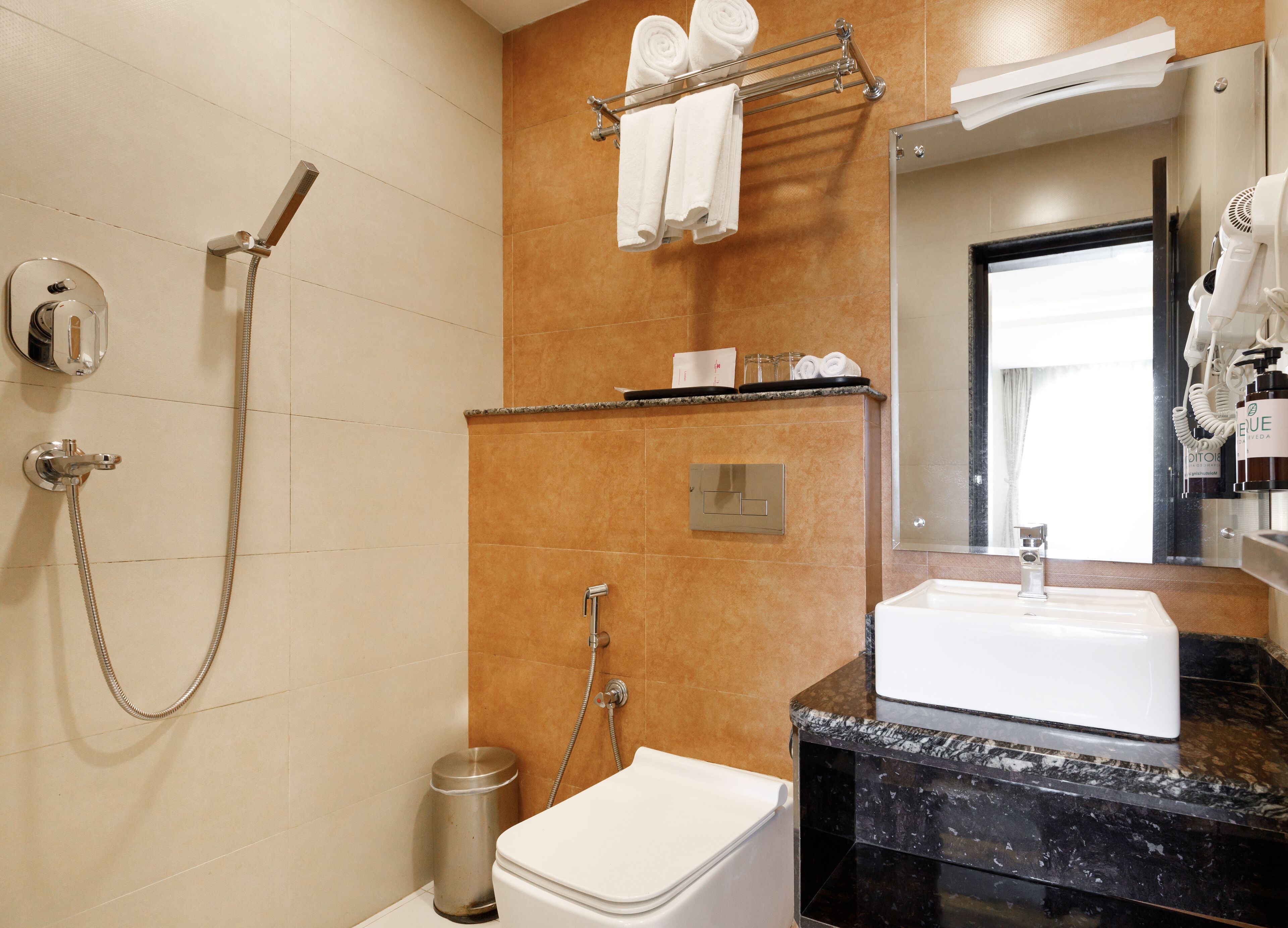 Ein modernes Badezimmer mit Dusche, Toilette, Waschbecken und Handtuchhalter.