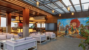 A modern lobby with seating areas, a bar, and a mural.