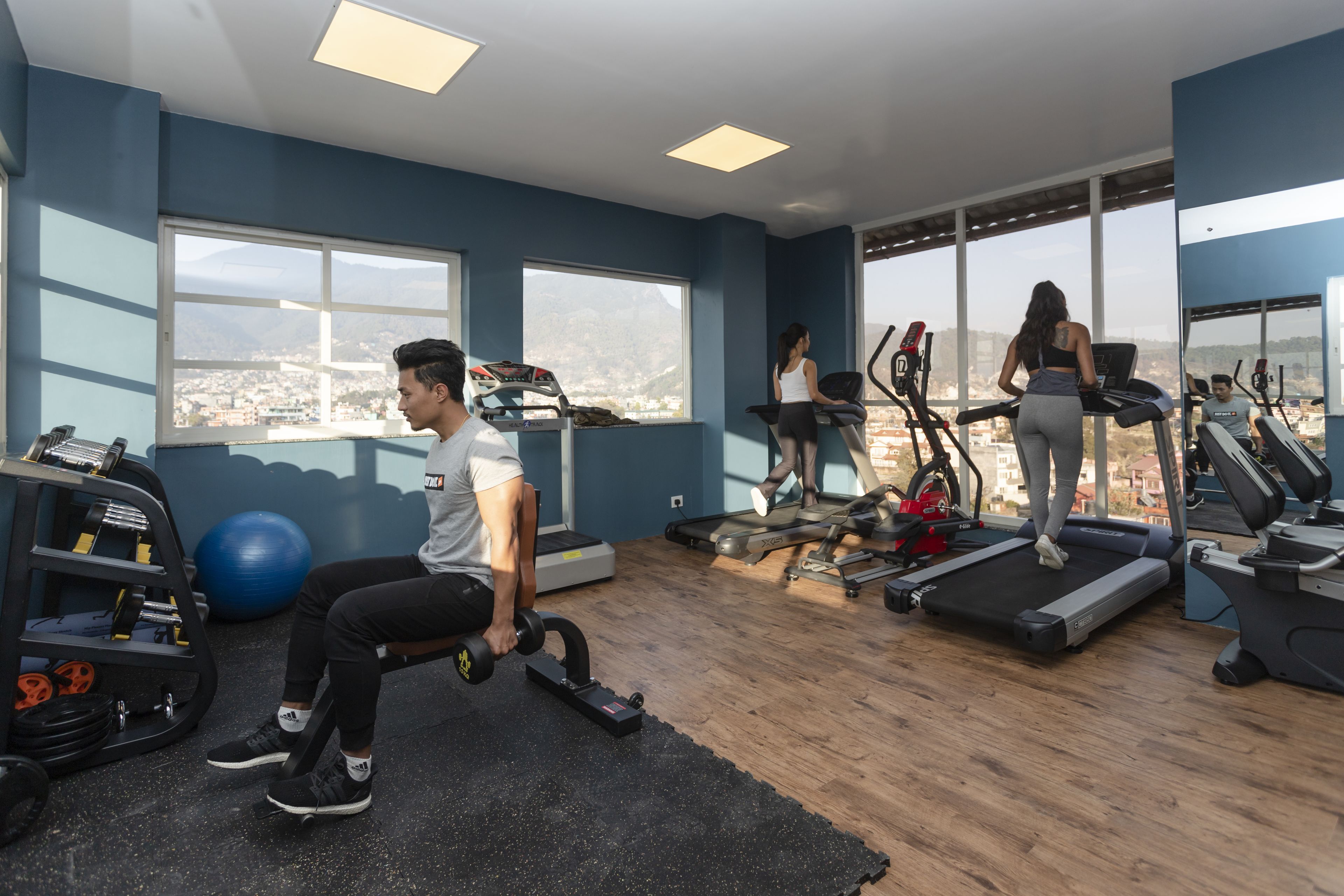 Een sportschool met loopbanden, fitnessballen en gewichten.