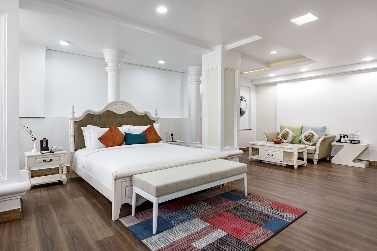 A modern bedroom with a large bed, bedside tables, a bench, and a coffee table.