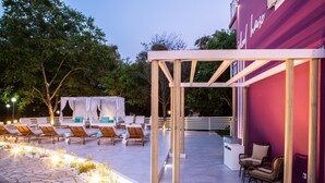 Un espace extérieur aménagé avec des fauteuils confortables et une structure en forme de pergola.