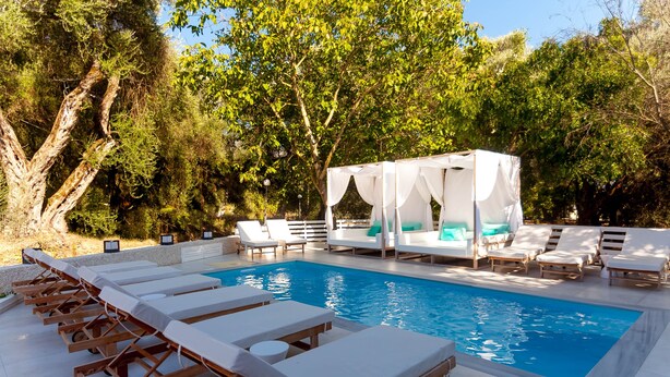 Un espace piscine avec des chaises longues et un auvent.