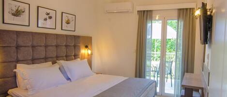 A bedroom with a large bed, a headboard, bedside tables, a wall-mounted TV, and a balcony with a view.