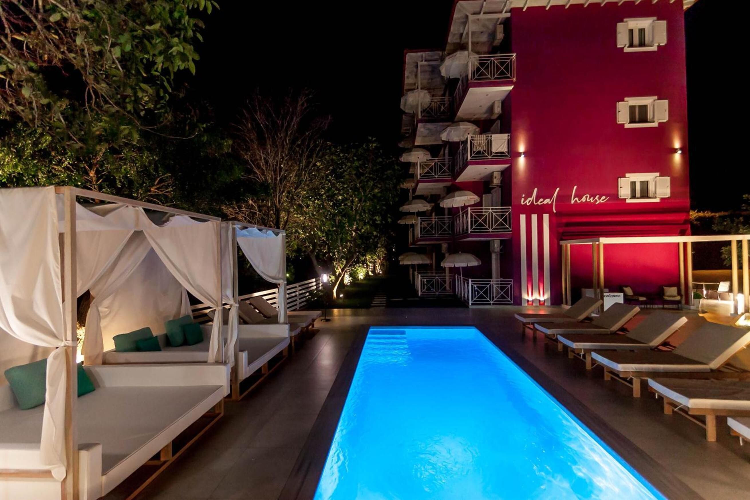 A pool area with lounge chairs and a canopy structure.