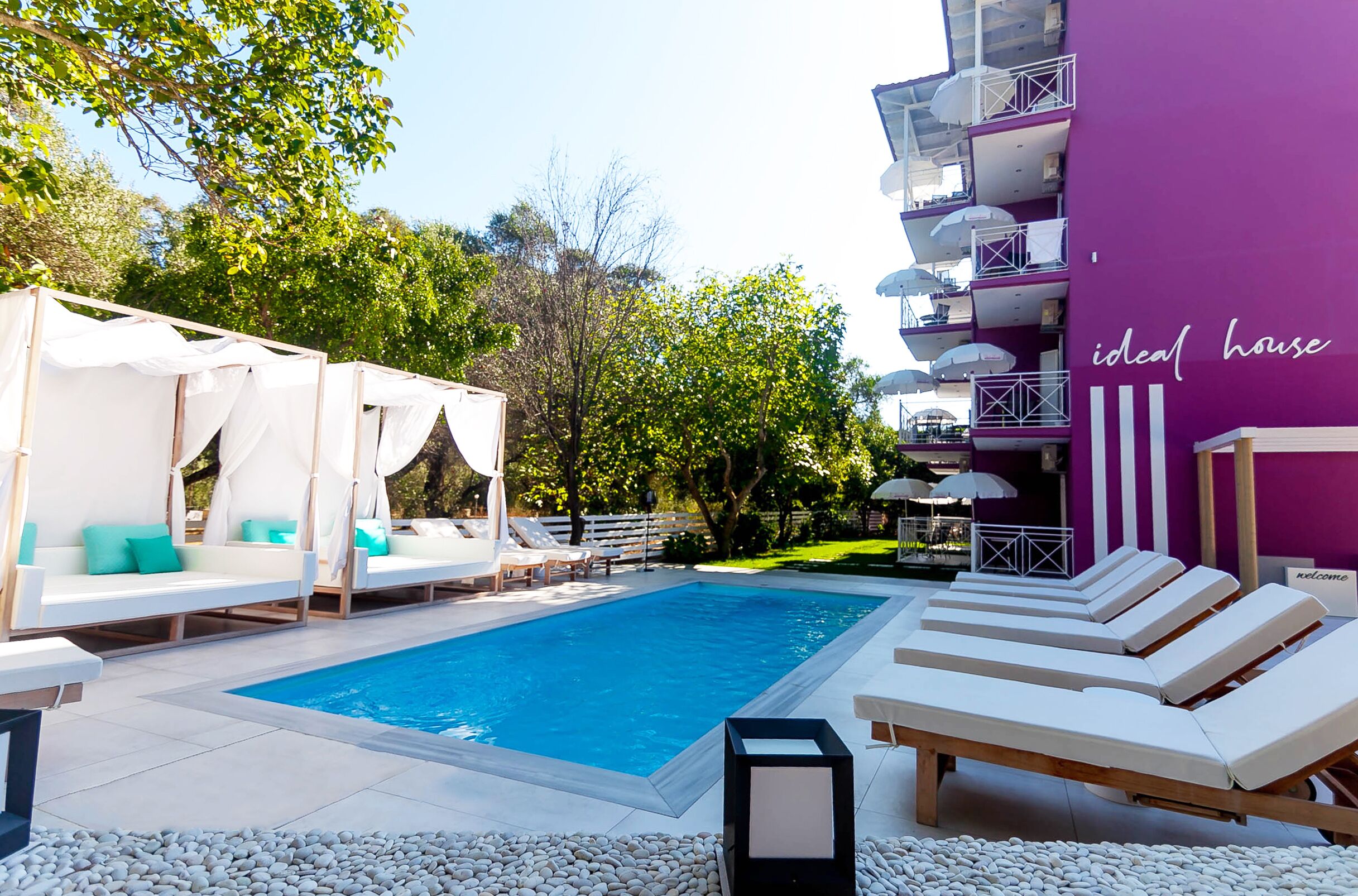 Un área de piscina con sillones reclinables y una estructura tipo sombrilla.