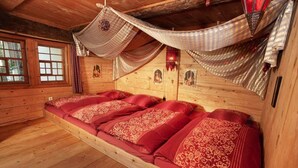 Una habitación de cabaña de madera con una cama grande, paredes de madera y una ventana.