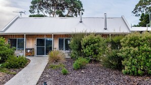 A modern building with a metal roof, large windows, and a wooden facade. - Greystone (FS5) - Freycinet Holiday Houses (Coles Bay)