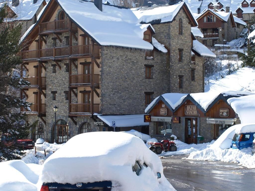 A snow-covered building with a stone facade and wooden balconies.
