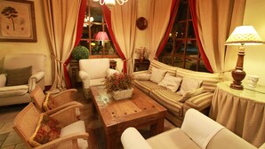 Ein gemütliches Wohnzimmer mit Couchtisch aus Holz, gestreifter Couch und Korbstühlen.