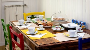 Una mesa de desayuno dispuesta con tazas, platos, pasteles y porciones de Nutella.