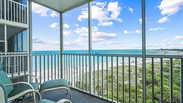Uma varanda com vista para a praia e o oceano.