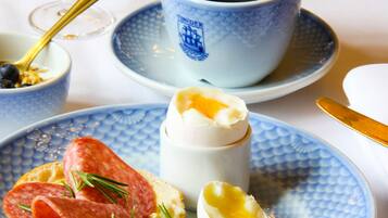 Un desayuno con un plato de comida, una taza de café y un vaso de jugo de naranja.