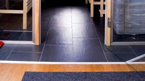 Une pièce mansardée avec un plafond en pente, des murs en pierre et un banc en bois.