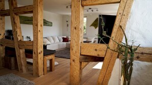 Un intérieur rustique avec des poutres apparentes, un canapé et une table basse.