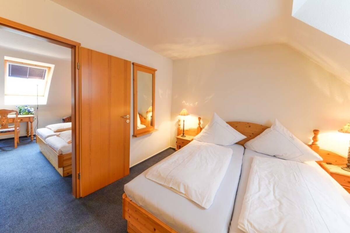 Un dormitorio con cama, escritorio, silla, armario y ventana.
