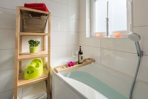 Ein modernes Badezimmer mit einer Holzeinrichtungsanlage, einer Badewanne, einem Fenster mit Aussicht und einer Dusche.