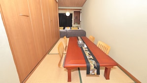 Una habitación tradicional japonesa con suelo de tatami, una mesa de madera y una cama futón.