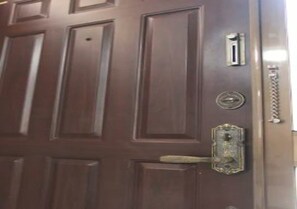 A wooden door with a brass handle and a keyhole.