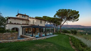 Une maison à deux étages dotée d’un patio et d’un espace repas.