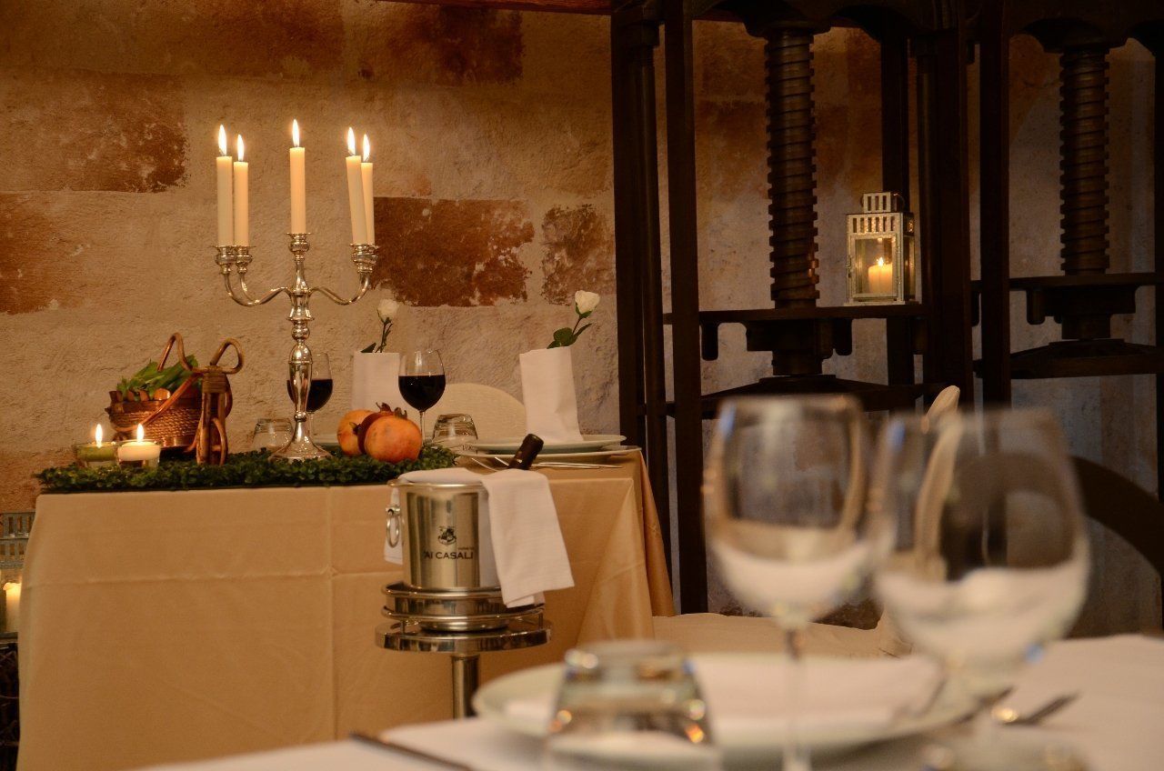 Une table à manger décorée avec des bougies, une machine à café et des verres à vin.