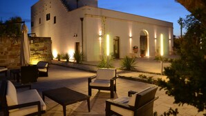 Un edificio moderno con un patio amueblado al aire libre y plantas en macetas.