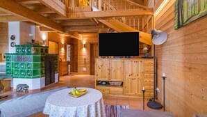 L’intérieur d’un chalet en bois comprend une télévision, une cheminée et un coin repas.