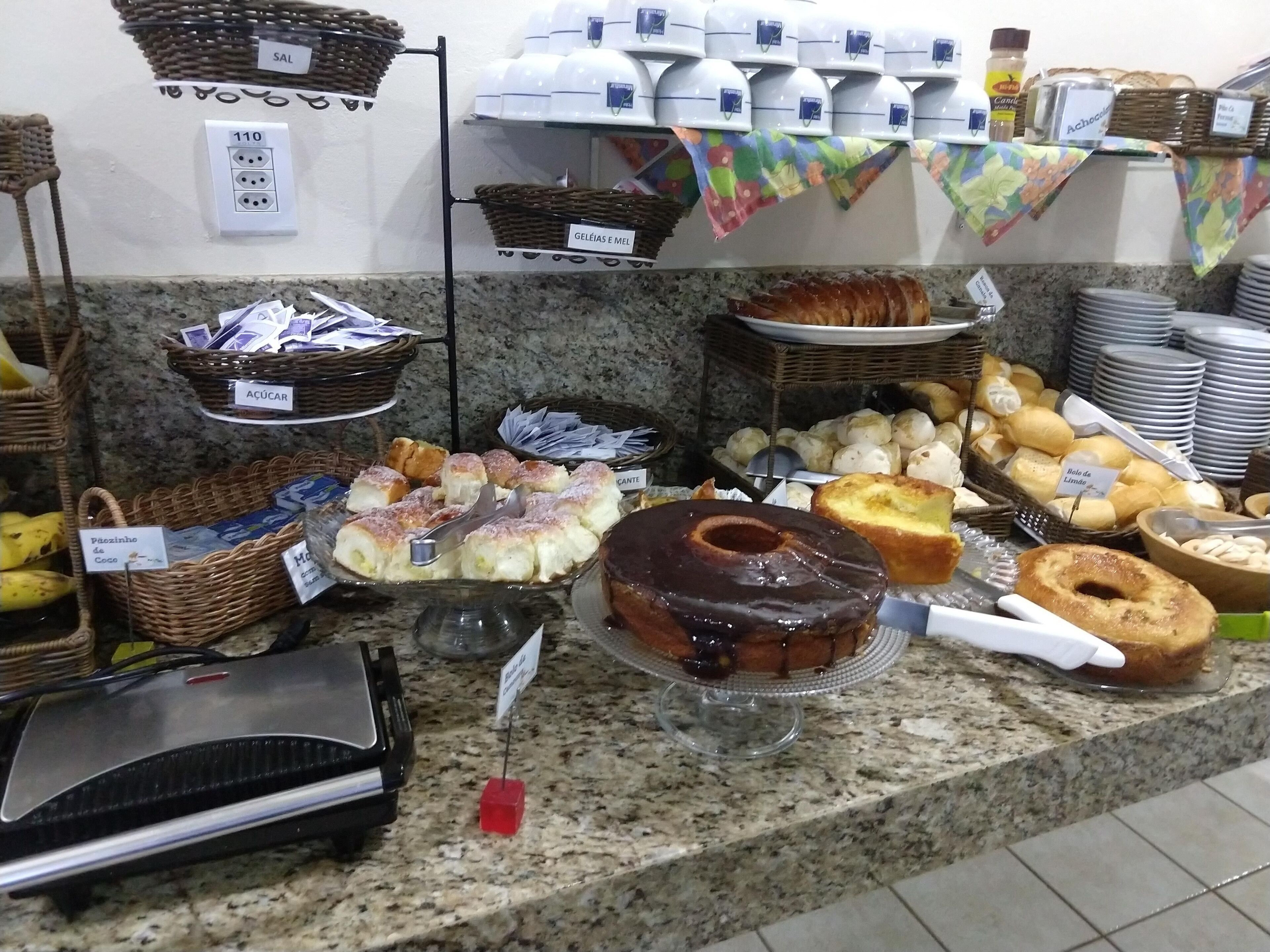 A buffet with various food items including cakes, pastries, and bread.