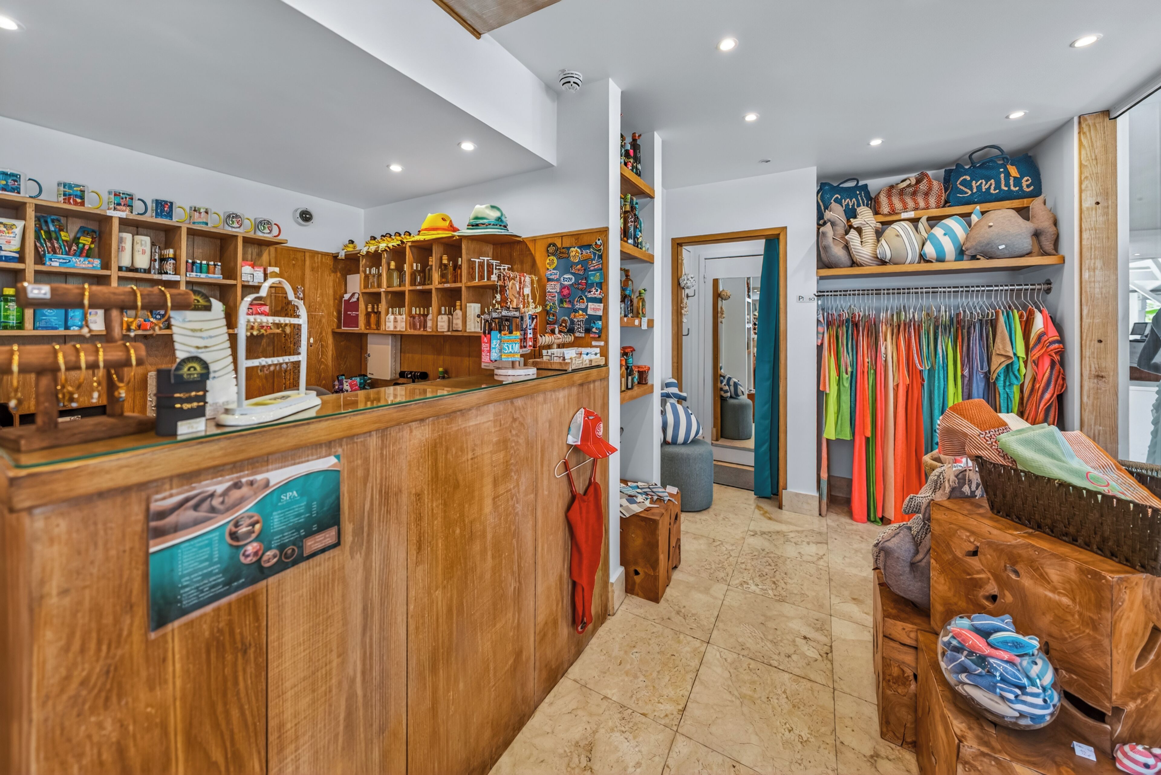 A boutique store with wooden shelving, a variety of hats, and a clothing rack.
